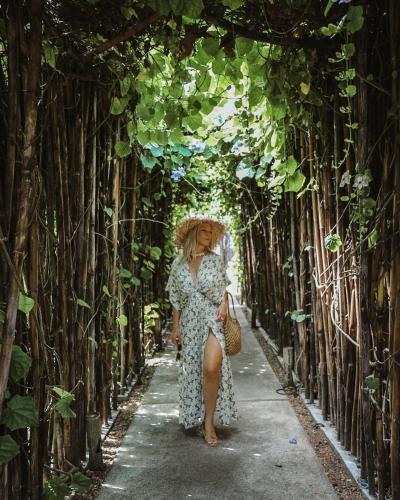 a woman walking down a path through a tunnel of trees at Rest Sea Resort Koh Kood in Ko Kood