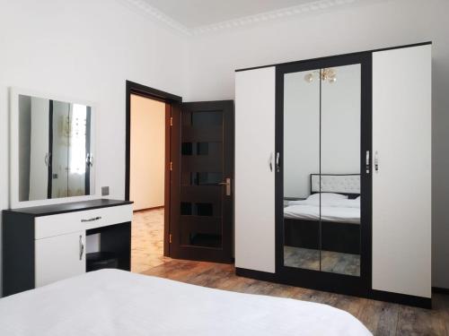 1 dormitorio con cama y espejo en Villa SUPER, en Gabala