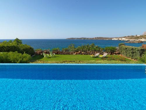 una piscina blu con vista sull'oceano di Villa Anemos by Estia a Kalathas