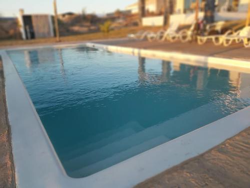 a swimming pool with blue water in front of a building at Playa Esperanza Resort in Celestino Gasca