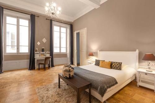 a bedroom with a large bed and a table at Les chambres chez Grand-mère à Chambéry in Chambéry