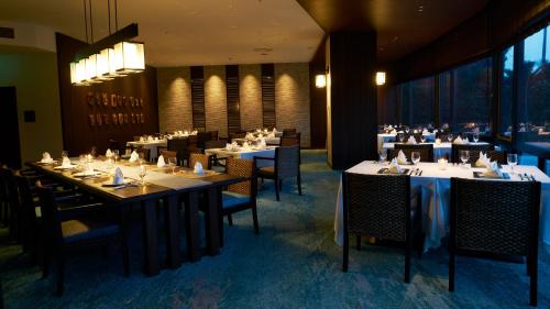 a dining room with tables and chairs in a restaurant at Shimoda Tokyu Hotel in Shimoda