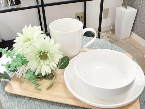 a table with two white plates and a coffee cup at OUCHI HOTEL Takaramachi in Hiroshima