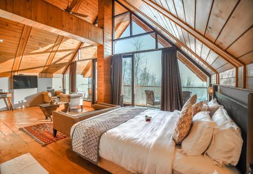 a bedroom with a large bed and a large window at Hotel Rah Bagh - Luxury Boutique Hotel in Bāgh Chandpura