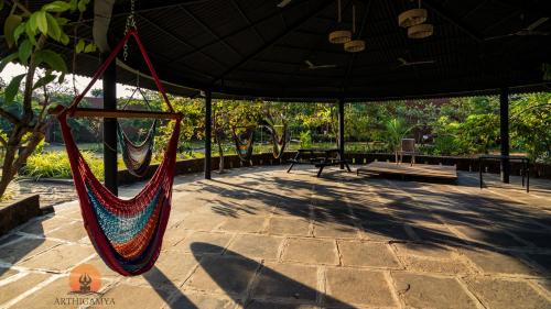 a hammock in a pavilion with a table and benches at Arthigamya Beach Front Resort & SPA in Gokarna