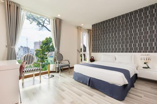 ホーチミン・シティにあるLam Kinh Hotelのベッドと大きな窓があるホテルの部屋