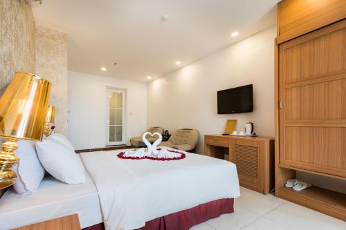 a hotel room with a bed and a tv at Lam Kinh Hotel in Ho Chi Minh City