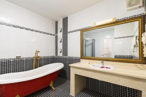a bathroom with a tub and a sink and a mirror at Lam Kinh Hotel in Ho Chi Minh City
