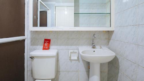 a bathroom with a sink and a toilet and a mirror at RedDoorz at The Providence Tower in Manila