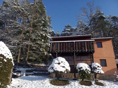 eine Hütte mit Schnee vor Bäumen in der Unterkunft chata FRIDAY in Ktová