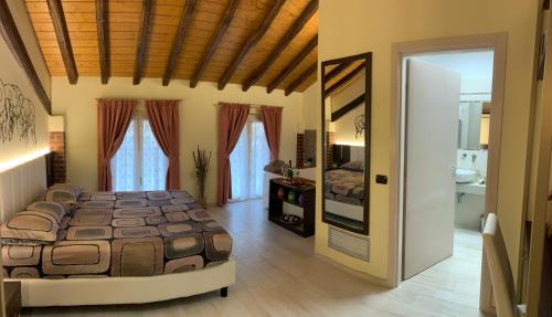 a bedroom with a large bed and a mirror at Agriturismo Le Risaie in Basiglio