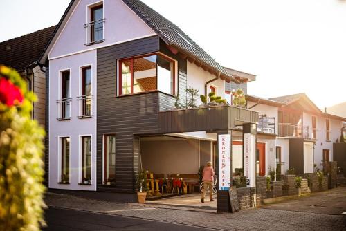 a woman riding a bike in front of a house at Pension Zur Krone in Martinfeld
