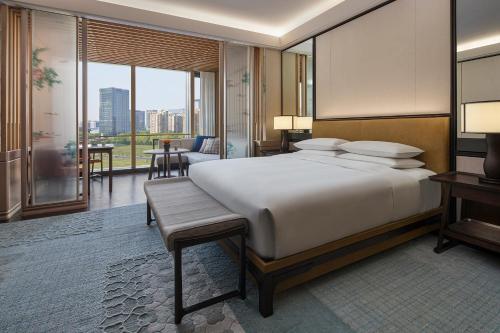 een slaapkamer met een groot bed en een groot raam bij Park Hyatt Suzhou in Suzhou