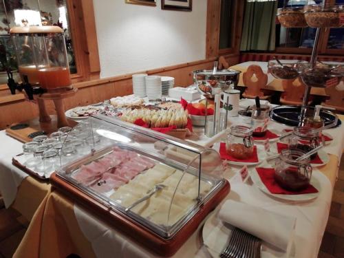 ein Tisch mit einem Buffet mit Speisen und Desserts in der Unterkunft Rifugio Capanna Passo Valles in Falcade
