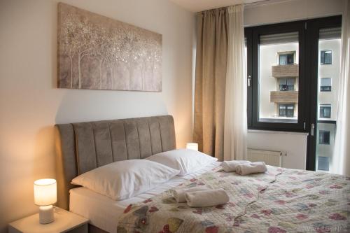 a bedroom with a bed with two towels on it at Nova Galerija Studio Vita i Apartman Sara -parking in garage in Zagreb