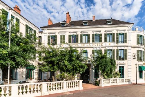 un bâtiment blanc avec un panneau indiquant la fiesta dans l'établissement Hôtel de la Poste, à Beaune