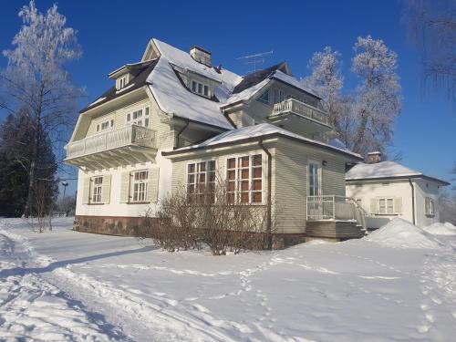 a large house with snow on the ground at Atpūtas komplekss "Ratnieki" in Ratnieki