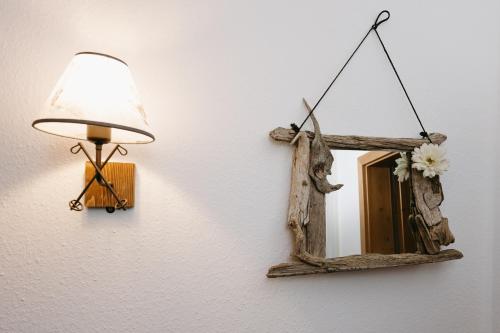 a mirror hanging on a wall with a lamp at Ferienhaus Heimhof in Garmisch-Partenkirchen