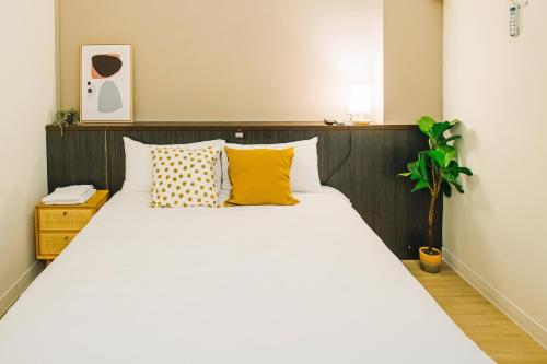 a bedroom with a large white bed with yellow pillows at Fun Trip - Fu May Sea View Holiday house l 無敵海景交誼廳 l 附汽機車租賃 l in Taitung City