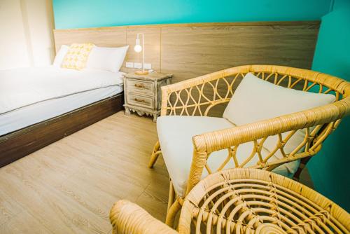 a bedroom with a bed and a chair and a table at Fun Trip - Fu May Sea View Holiday house l 無敵海景交誼廳 l 附汽機車租賃 l in Taitung City
