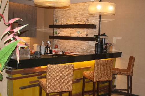 a kitchen with a bar with two chairs in it at De Arni Bangkok - SHA Extra Plus in Bangkok