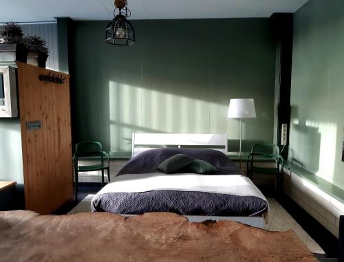 1 dormitorio con 1 cama con pared verde en Middelpunt Opmeer, en Opmeer