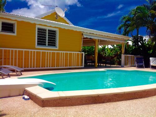レ・トロワ・イレにあるLa Villa Madininaの家の前にプールがある家
