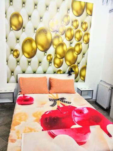 皮羅特的住宿－Apartman Jasna,，一间卧室设有一张床和一个带金色气球的墙壁