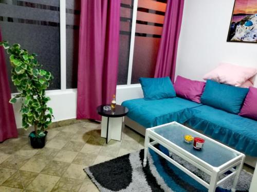 皮羅特的住宿－Apartman Jasna,，客厅配有蓝色的沙发和粉红色的窗帘