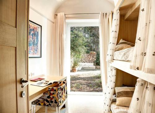 a room with a desk and a bed and a window at Villa Marina Little Beach in Capri