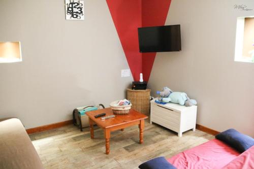 ein Wohnzimmer mit einem Sofa und einem Tisch in der Unterkunft Gîte De La Souris Verte in Molamboz