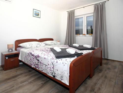 a bedroom with a bed with white sheets and a window at Apartment Milenka in Čilipi