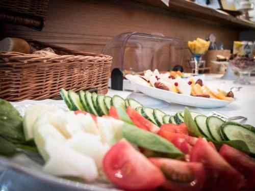a table topped with plates of fruits and vegetables at Hotel Wandersleben - Erfurt in Wandersleben