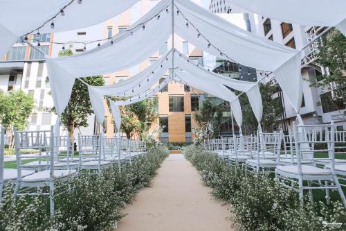 a wedding aisle with white chairs and a marquee at Grand Richmond Stylish Convention Hotel in Nonthaburi