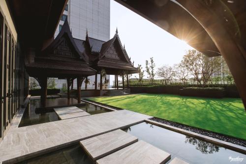 an external view of a building with a green lawn at Grand Richmond Stylish Convention Hotel in Nonthaburi