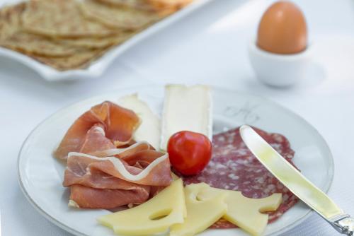a plate of food with meat and cheese on a table at Hôtel la Magnaneraie in Villeneuve-lès-Avignon