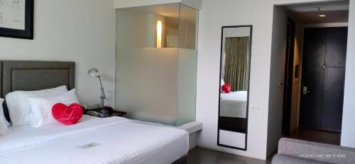 a hotel room with a bed and a mirror at Sugar Palm Grand Hillside - SHA Plus in Kata Beach