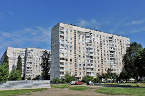 ハルキウにあるВалентиновская 13а метро Студенческая 1к квартира со всеми удобствамиの公園前の大きなアパートメントビル