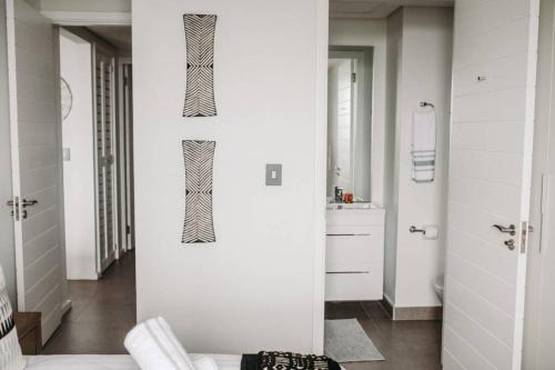 a white bathroom with black and white walls at Luxury Apartment near the Airport with Sea View in Umhlanga