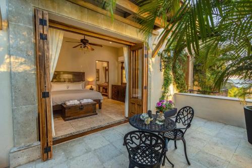 a patio with a table and chairs and a bed at 1037 - Villa Escondida in Santa Cruz Huatulco