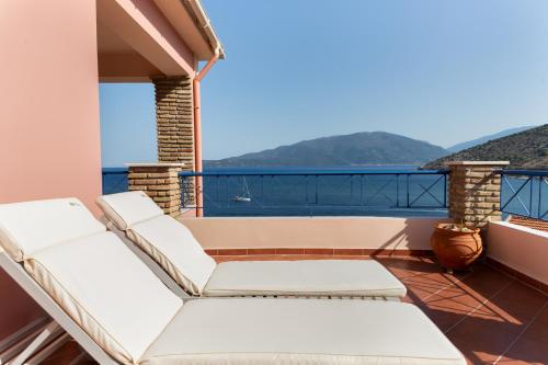 a balcony with white furniture and a view of the ocean at Natassa Apartments Penthouse sea view 30m from sea in Ayia Evfimia