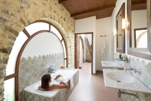 Eine Frau, die in einer Badewanne im Badezimmer sitzt. in der Unterkunft Hotel Punta Sur in Tarifa