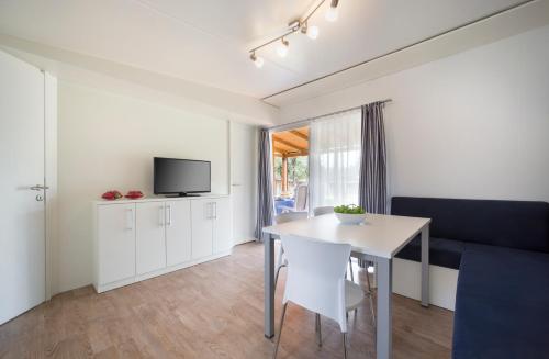 
a living room with a table and a tv at Mobile Homes Polari in Rovinj
