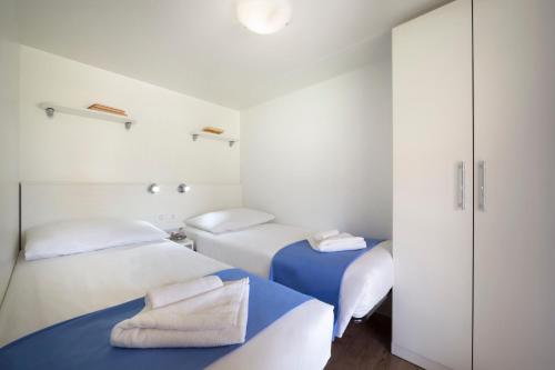 Duas camas num quarto com paredes brancas em Maistra Camping Polari Mobile homes em Rovinj