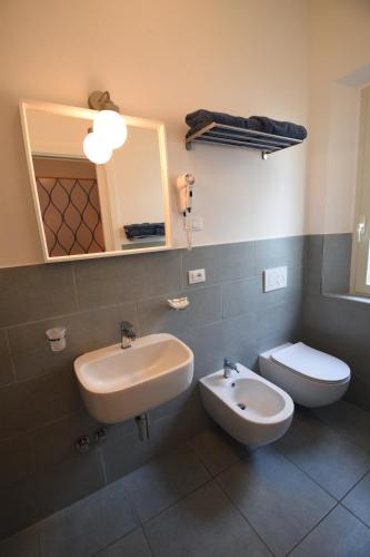 La salle de bains est pourvue d'un lavabo, de toilettes et d'un miroir. dans l'établissement Hotel la Conchiglia, à Campo nell'Elba