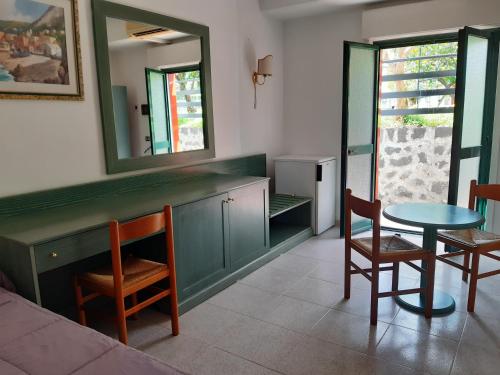 a room with a table and chairs and a mirror at Villaggio Alkantara in Giardini Naxos
