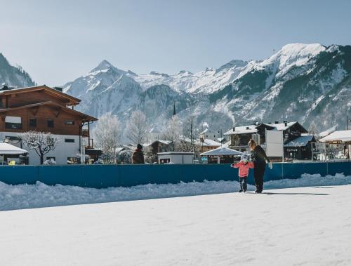 a woman and a child walking in the snow at Aparthotel Waidmannsheil in Kaprun