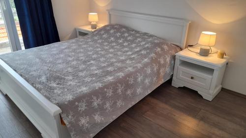 um quarto com uma cama e duas mesas de cabeceira com candeeiros em Apartments Lumbarda em Lumbarda
