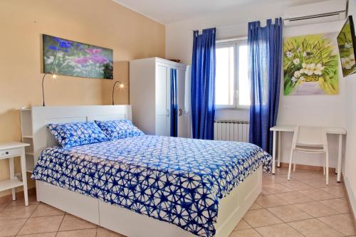 B&B Etna Europa في سان غريغوريو دي كاتانيا: غرفة نوم مع سرير مع لحاف أزرق