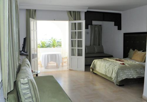 a bedroom with a bed and a sliding glass door at Residence Ain Meriem in Bizerte